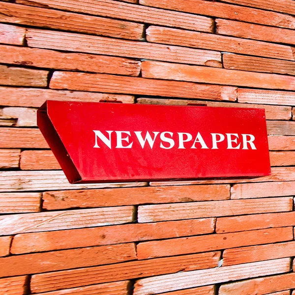 Newspaper box on brickwall
