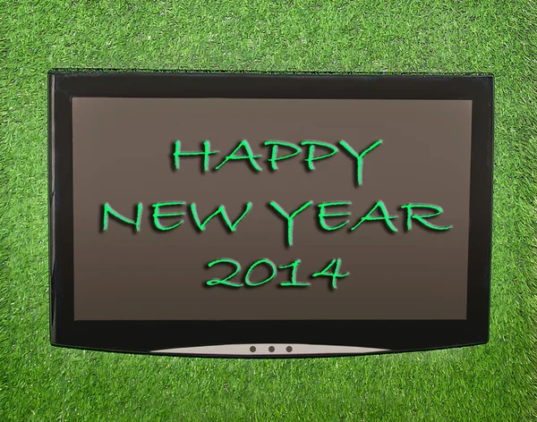 Lcd screen on artificial green grass of happy new year 2014 — Stock Photo, Image