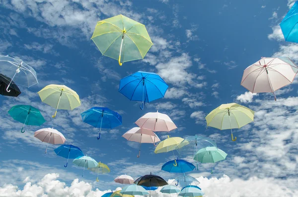 Mångfärgade paraplyer mot blå himmel bakgrund — Stockfoto