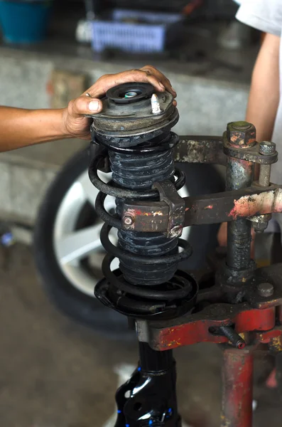 Auto car mechanic working on car shock absorber in car service w — Stock Photo, Image