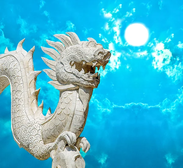 Скульптурный цемент дракона изолирован на голубом фоне неба — стоковое фото