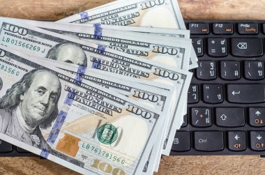 klavye üzerinde 100 dolar faturaları yığını