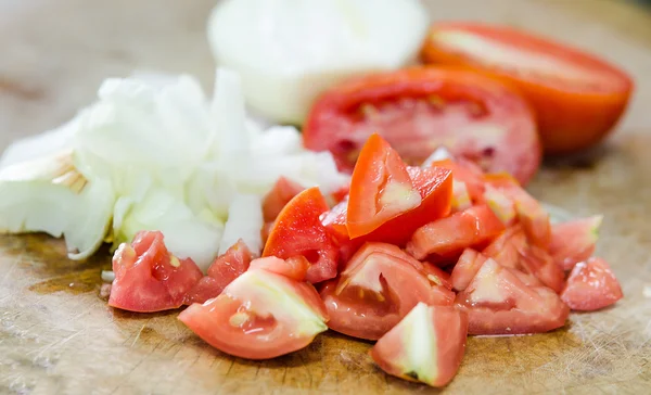 Chop tomato and onion on chopping wood — Stock Photo, Image