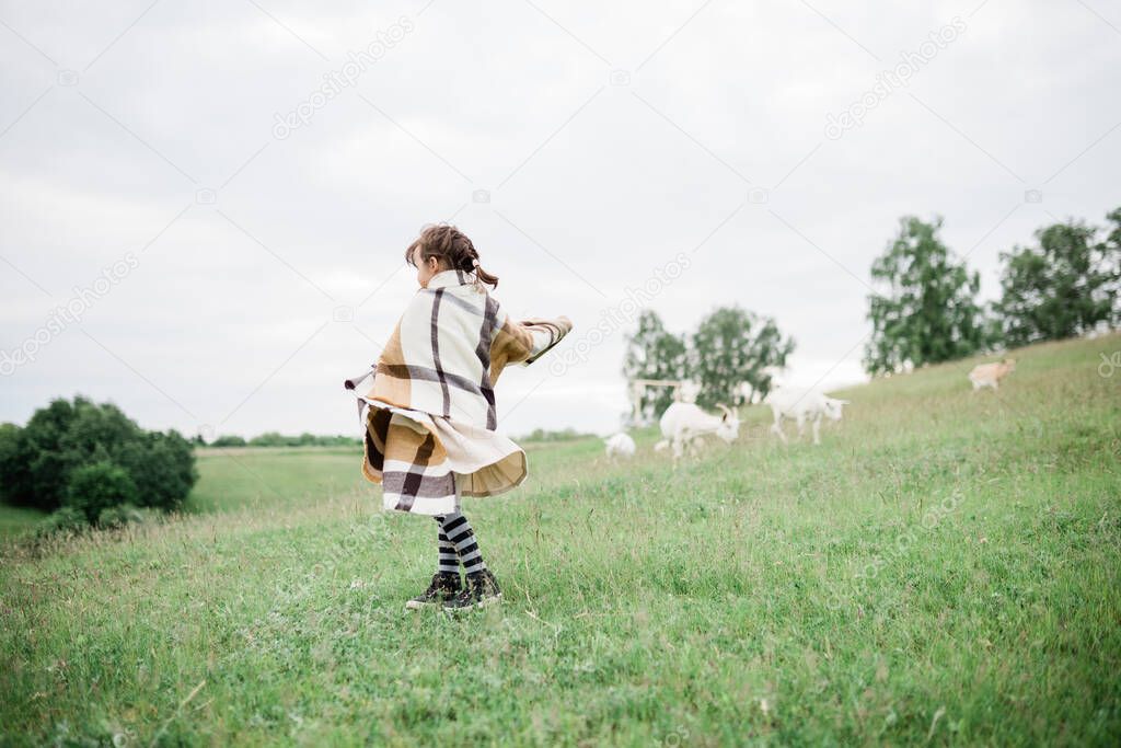 Young girl on the green hills on the farm