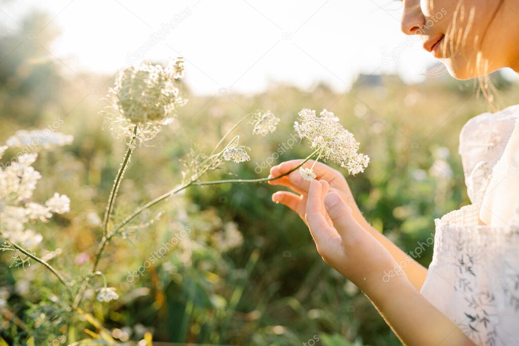 Happy little girl in the field of Queen Annes Lace flower