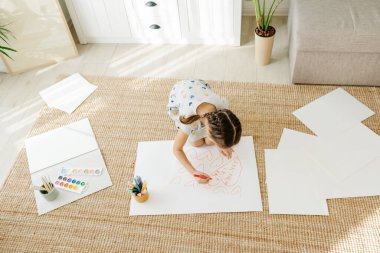 Çocuk bir sürü kalp çiziyor.