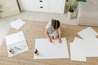 Çocuk bir sürü kalp çiziyor.