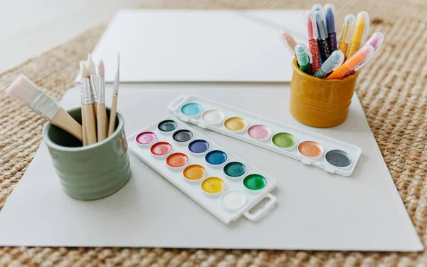 Watercolor paper, paints and paintbrushes — Stock Photo, Image