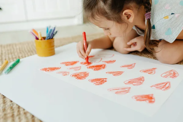 Child drawing a lot of hearts — Stock Photo, Image