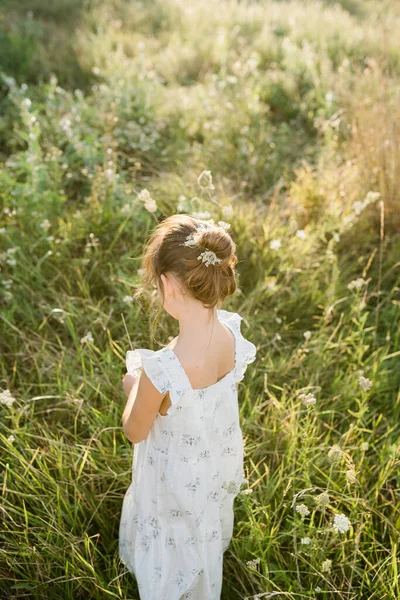Lycklig liten flicka på fältet för drottning Annes spets blomma — Stockfoto
