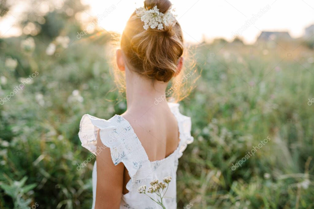 Happy little girl in the field of Queen Annes Lace flower