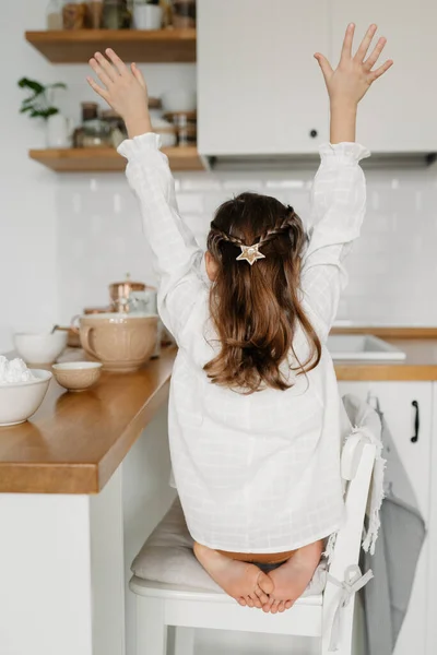 Little Caucasian brown-haired girl baking on white kitchen at home — Stock Photo, Image