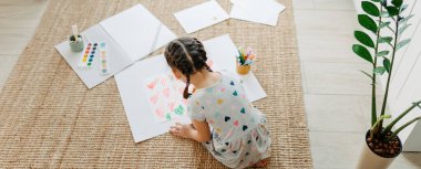 Çocuk bir sürü kalp çiziyor.