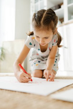 Çocuk bir sürü kalp çiziyor.