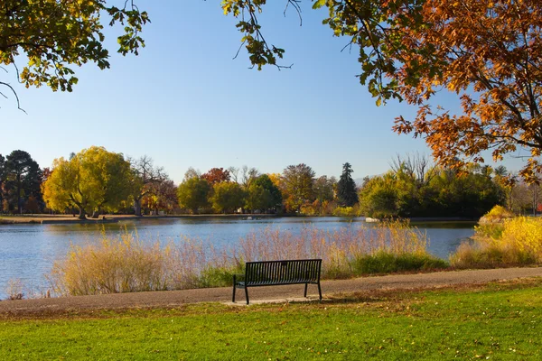 Banco de parque vacío junto a un lago en otoño - Denver — Foto de Stock