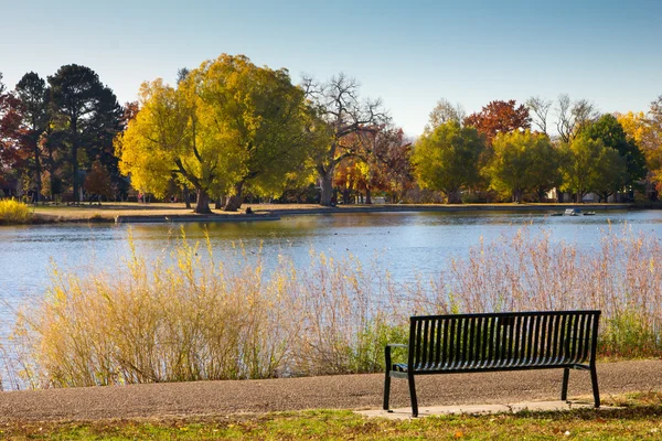 Banco de parque vacío junto a un lago en otoño - Denver — Foto de Stock
