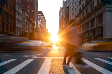 5. Cadde 'de kalabalık kavşaktan geçen insanlar ve arabalar 5. Cadde' de gün batımı ışıklarıyla New York, Manhattan 'da parlıyor.