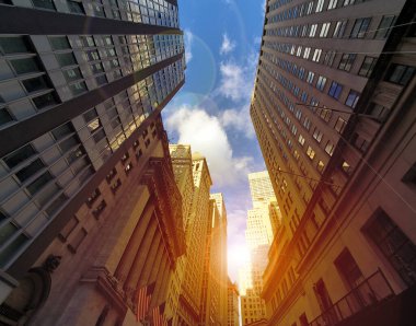 New York 'un Finansal Bölgesi' ndeki Wall Street 'in tarihi binaları arasında gün ışığı parlıyor.