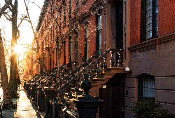 Block of historic brownstone buildings on Charles Street in the West Village neighborhood of New York City NYC