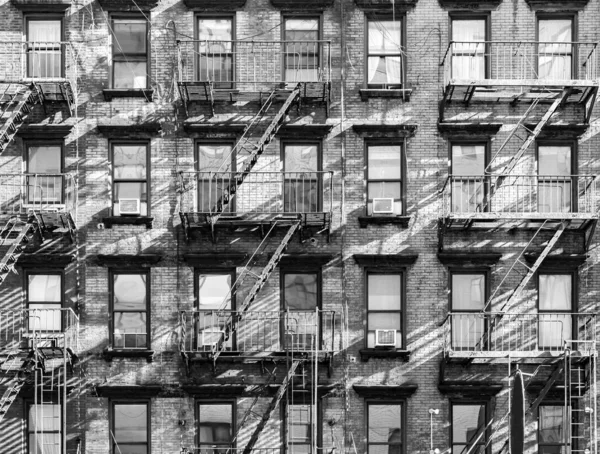 纽约市黑白相间的带有窗户和防火梯的旧公寓楼的外景 — 图库照片