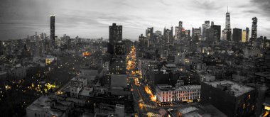 New York şehrinin sarı ışıkları Manhattan 'ın aşağısında siyah beyaz bir şehir manzarasına karşı parlıyor.