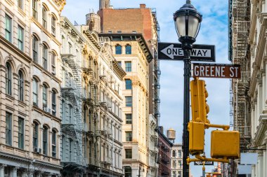 Greene Street sign and old historic buildings at an intersection in SoHo New York City NYC