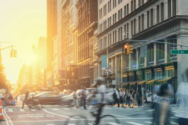Busy downtown street scene with crowds of people walking through a crowded intersection on 5th Avenue in New York City with colorful light shining