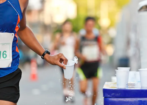 Su bardağı yakalamak maratonda yarışçı - Stok İmaj