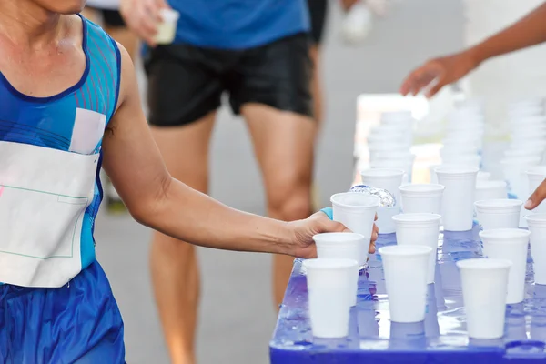 Su bardağı yakalamak maratonda yarışçı Telifsiz Stok Fotoğraflar