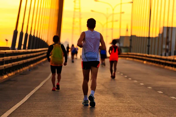 Löpare springa på bron på morgonen — Stockfoto