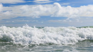White clean sea waves of tropical beach with blue sky and clouds in colorful sunny day. Scene of summer vacation and holiday business travel concept. Layers of splash water and sky background.