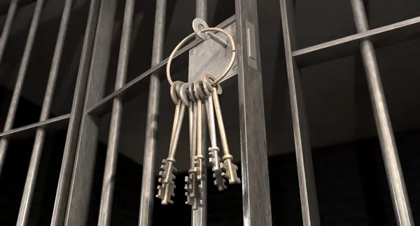 Gevangenis cel met open deur en bos van sleutels Stockfoto