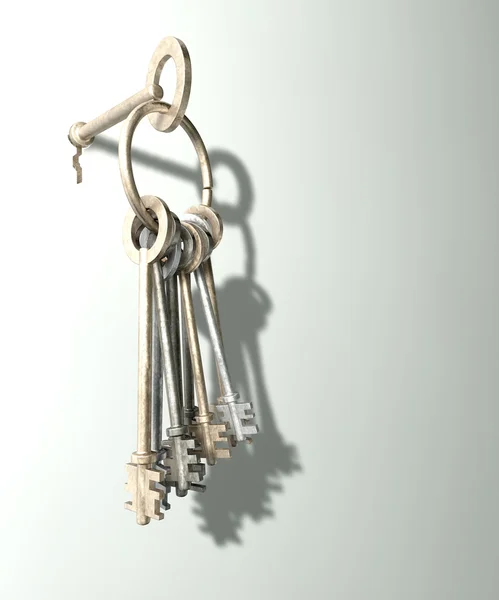 Eine Reihe alter Schlüssel, die an einem Reifen hängen, der von einem in ein Schlüsselloch auf weißem Wandhintergrund gesteckt wird — Stockfoto