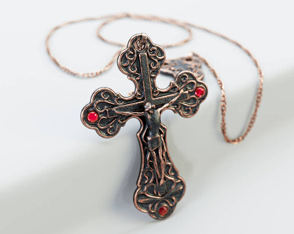A closeup of an ornate brass antique rosary chain necklace with a crucifix draped on an isolated white background - 3D render