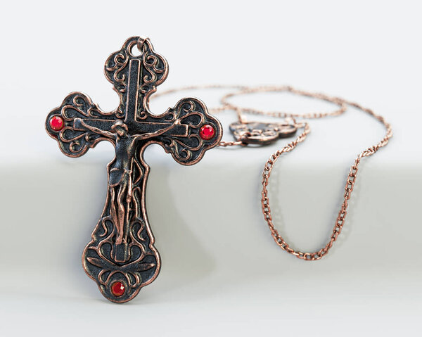 A closeup of an ornate brass antique rosary chain necklace with a crucifix draped on an isolated white background - 3D render