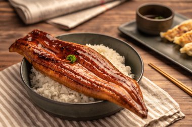 Yakın plan Japon ızgara yılanbalığı pilav ya da Unagi Don tabakta servis edilir. Restoran masasında Japon yemeği.