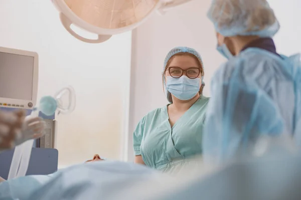 Nurse assisting doctors during surgery in operation room of clinic. High quality photo