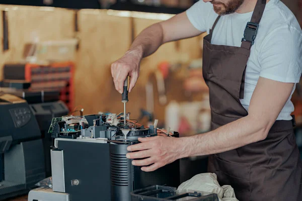 Close up of man hands repairing coffee machine in a workshop and holding some necessary details