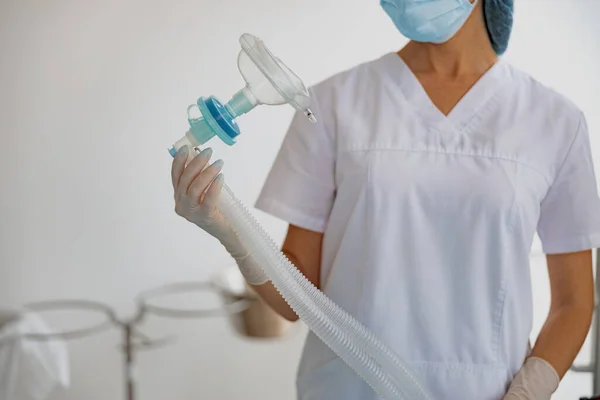 Close up o nurse holding mask for anesthesia standing in operation room. High quality photo
