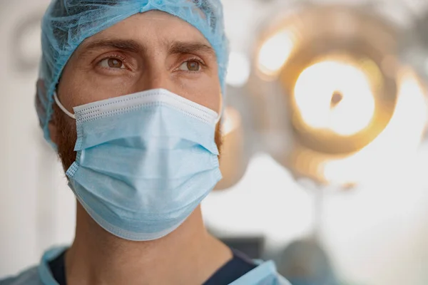 Close up of doctor in mask standing in operating room before surgery. High quality photo