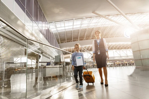 Airport worker helps little boy to find correct gate for boarding at the airport. High quality photo