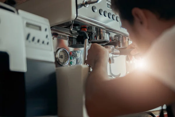 Man worker in uniform inspecting coffee machine in own workshop. High quality photo