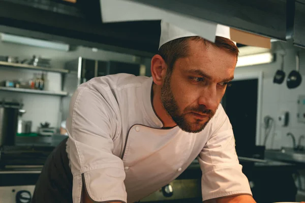 Tired chef on kitchen restaurant waiting for a new order. High quality photo