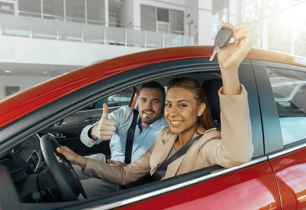 Happy couple is choosing rental car at dealership for traveling. Auto purchase and rental concept