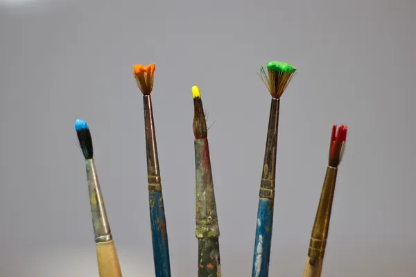 Brushes and paints in a row — Stock Photo, Image