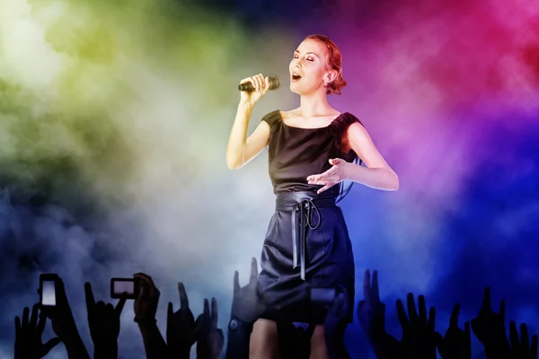 Portréja egy nő énekel egy koncerten rajongói számára Stock Kép