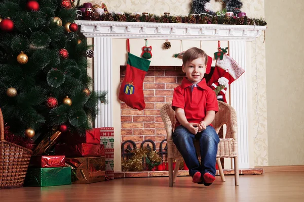 Glücklicher kleiner Junge vor dem Weihnachtsbaum wartet lizenzfreie Stockfotos
