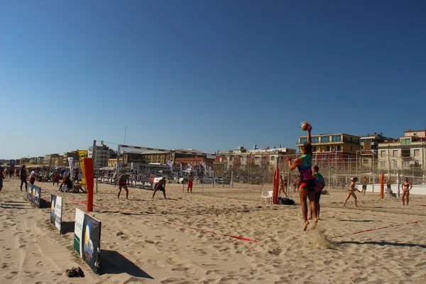 Plaj voleybolu atletlerinin bu maçta eksik olmayan sıcaklığa ve kuma karşı çok iyi eğitilmiş harika bir fiziği vardır.