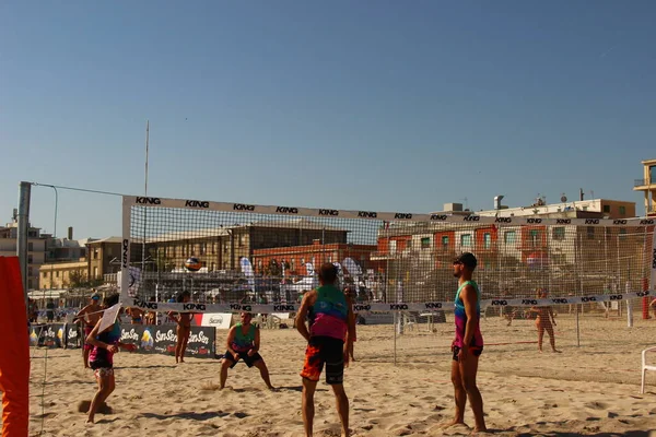 Plaj voleybolu atletlerinin bu maçta eksik olmayan sıcaklığa ve kuma karşı çok iyi eğitilmiş harika bir fiziği vardır.