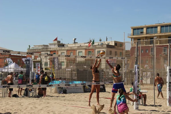 Plaj voleybolu atletlerinin bu maçta eksik olmayan sıcaklığa ve kuma karşı çok iyi eğitilmiş harika bir fiziği vardır.